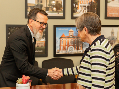 Rocky Nichols, DRC Executive Director, and Governor Laura Kelly, shake hands.