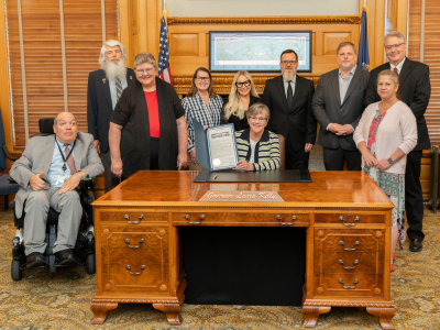 Disability advocates pose with the Governor and the signed proclamation. 